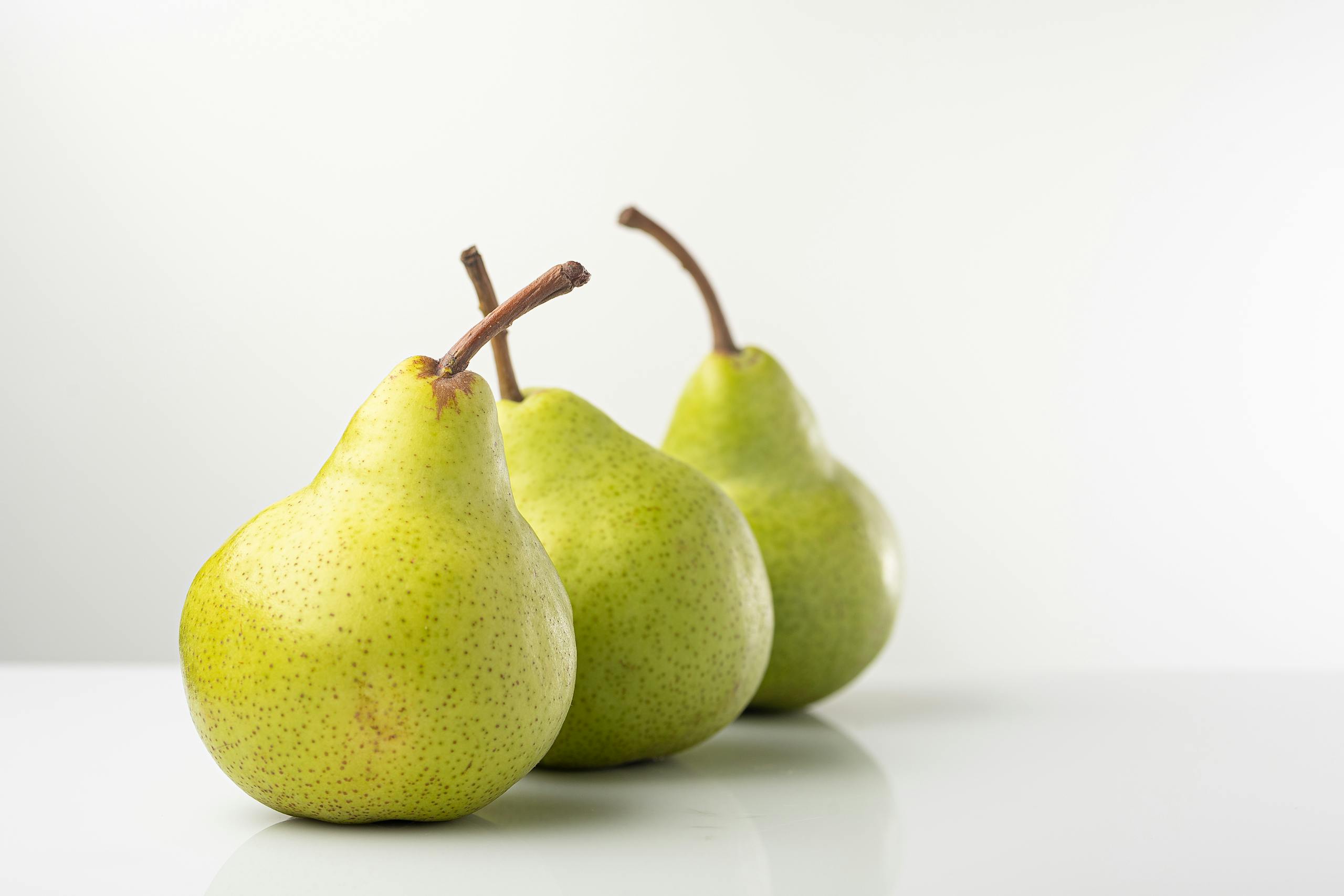 A close-up of ripe green pears in a studio setting, perfect for healthy eating themes.